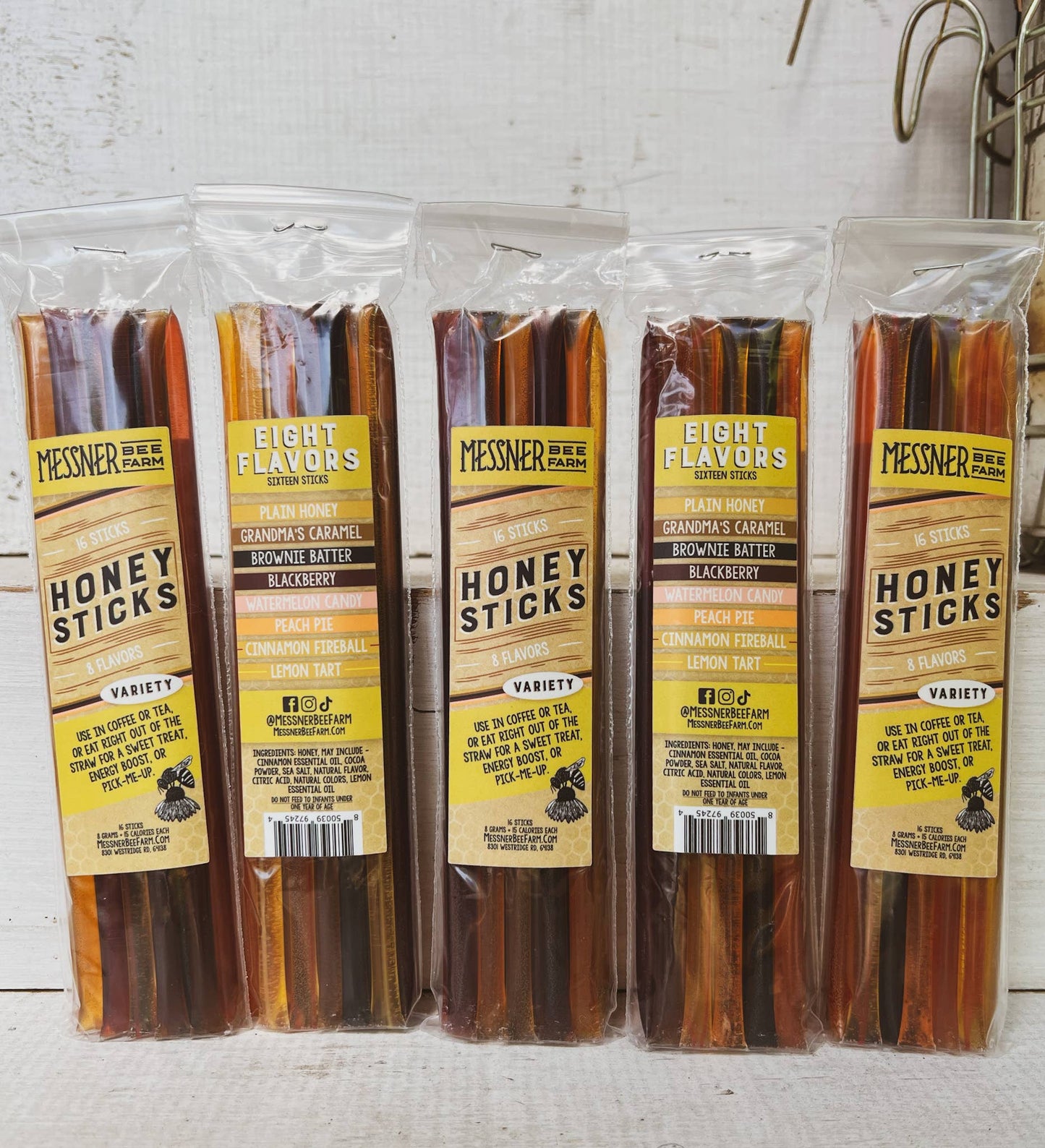 Packaged honey sticks with Messner Bee Farm labels on a white background